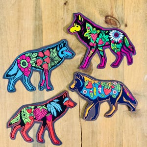 May include: Four colorful wolf stickers with floral and strawberry designs. The wolves are in different poses and have a variety of colors, including blue, pink, yellow, and green.