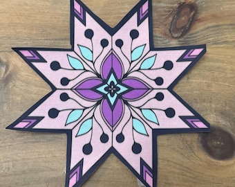 May include: A pink, purple, and blue star-shaped sticker with a geometric design. The sticker has a black outline and a white background.