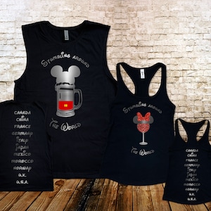 May include: Three black tank tops with a silver glitter design. The front of the shirts feature a Mickey Mouse head with a beer mug, a Minnie Mouse head with a wine glass, and the text "Stumbling Around The World". The back of the shirts feature a list of countries.