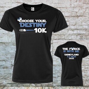 Puede incluir: Camiseta de running negra con un diseño de purpurina azul que dice "Choose Your Destiny 10K" en la parte delantera y "The Force Is With Me Disneyland 6.2 Miles 2025" en la parte trasera.