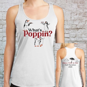 May include: A white racerback tank top featuring a graphic of three penguins and the red text "What's Poppin?". The back of the tank top displays a black umbrella, two clouds, and the text "Disney Wine & Dine Half Marathon 2026" in red and black.