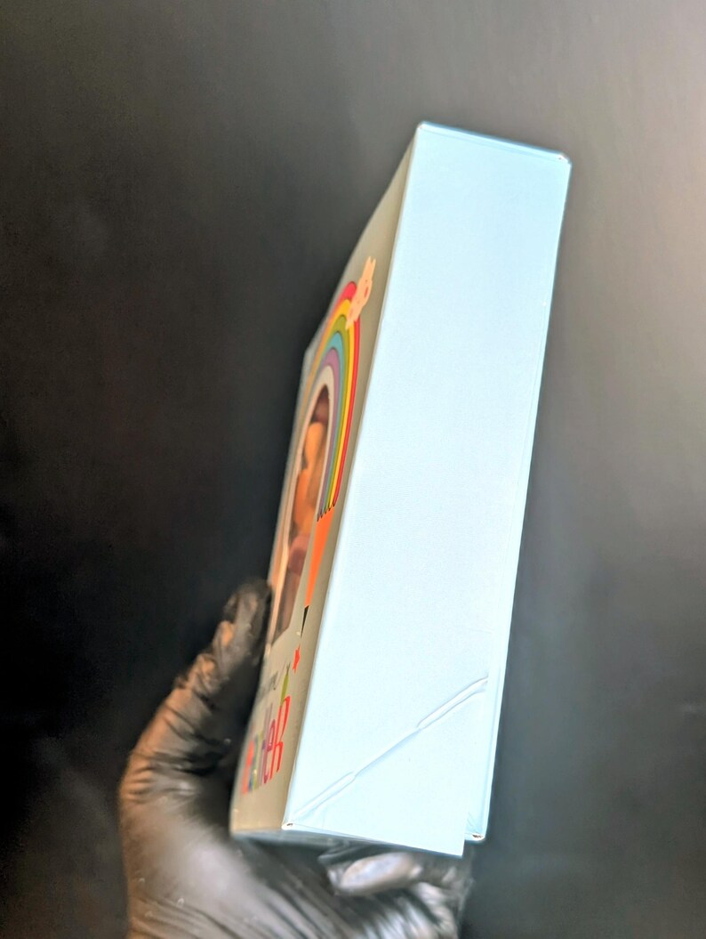 Puede incluir: Una caja azul claro con un arco&iacute;ris y una cara sonriente en la parte delantera. La caja tiene las palabras "Keep Calm and Carry On" impresas en la parte delantera.