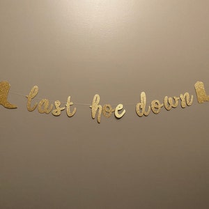 May include: Gold glitter banner with the text "Last hoe down" and two boot cutouts on either end.