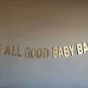 May include: Gold glitter banner with the text "It's All Good Baby Baby".