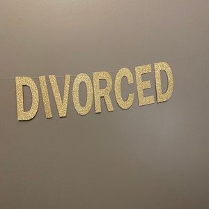 May include: A gold glitter banner with the word "DIVORCED" spelled out.