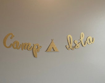 May include: Gold glitter banner with the words "Camp Isto" and a tent graphic.
