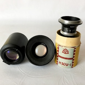 May include: A black lens with a silver aperture ring in a yellow and red box with the text "И50У-1".