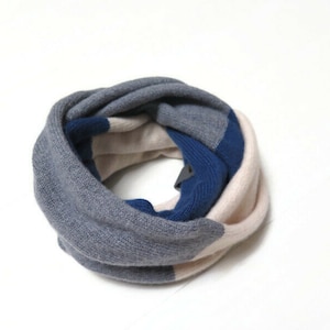May include: A gray, white, and blue striped infinity scarf. The scarf is made of a soft, knitted fabric.