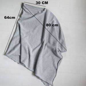 May include: A gray knitted poncho with a 30-inch neck opening, 64-inch length, and 80-inch width.