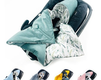 May include: A green and white baby car seat cover with a leafy pattern. The cover has a hood and is made of soft, quilted fabric. The cover is shown in a car seat.
