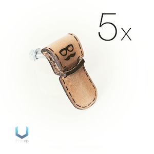 May include: Set of five brown leather cabinet pulls with a black graphic of a pair of glasses and a mustache. Each pull has a silver screw.