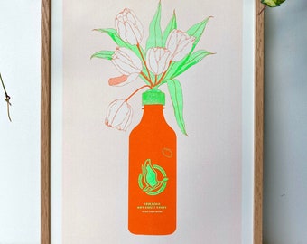 May include: A framed print of a white tulip bouquet in a bright orange bottle with a green lid. The bottle has a green bird logo and the text "Sriracha Hot Chili Sauce" on it.