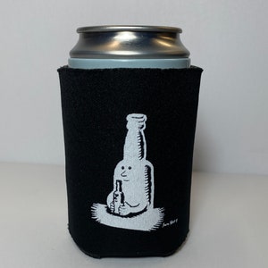 Peut inclure: Glaci&egrave;re en n&eacute;opr&egrave;ne noire avec une illustration blanche d'un personnage en bouteille tenant une plus petite bouteille. L'illustration est sign&eacute;e "Sam Hurt".