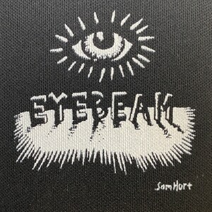 Peut inclure: Illustration en noir et blanc d'un &oelig;il avec un motif de soleil &eacute;clatant au-dessus du mot "EYEBEAM" dans une police de caract&egrave;res stylis&eacute;e. La signature de l'artiste "Sam Hurt" se trouve dans le coin inf&eacute;rieur droit.