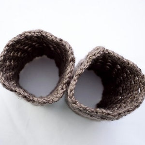May include: Two brown crocheted wrist warmers with a sparkly thread woven into the fabric.