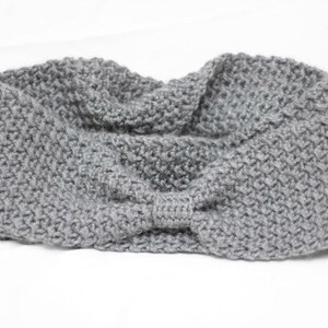May include: A grey knitted headband with a knotted bow detail.
