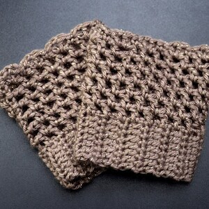 May include: Two brown crocheted arm warmers with gold glitter thread woven throughout. The arm warmers are folded together.