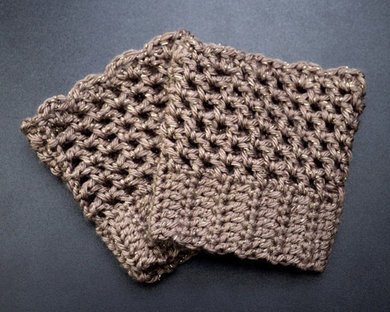 May include: Two brown crocheted arm warmers with gold glitter thread woven throughout. The arm warmers are folded together.
