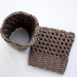 May include: Two brown crocheted pieces with a sparkly thread. One piece is a tube and the other is a square.
