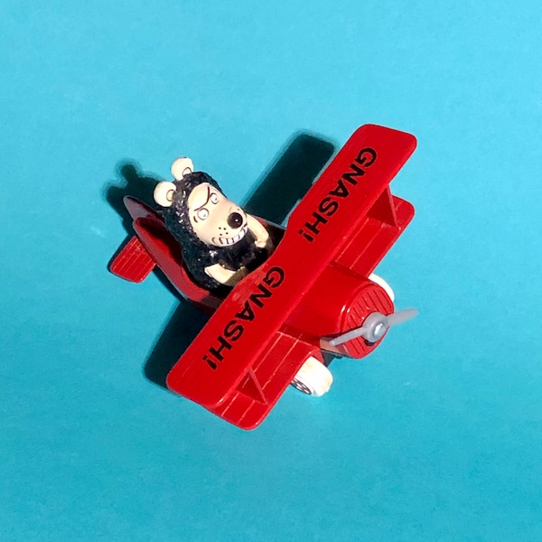 Dennis the Menace Gnasher in red diecast airplane.