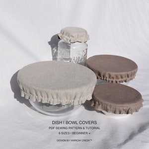 May include: Six different sizes of linen dish and bowl covers in beige and brown with ruffled edges. The covers are shown on glass jars and bowls. The text "DISH I BOWL COVERS" is printed in black on a white background. The text "PDF SEWING PATTERN & TUTORIAL" is printed in black on a white background. The text "6 SIZES I BEGINNER +" is printed in black on a white background. The text "DESIGN BY YARROW CREEK™" is printed in black on a white background.
