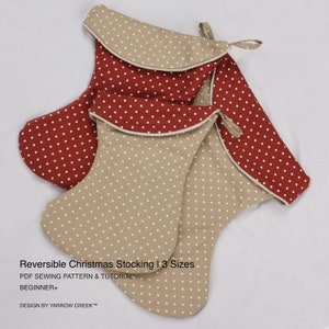 Puede incluir: Tres calcetines navideños reversibles. Dos son de color beige con lunares blancos, y el tercero es rojo con lunares blancos. Tienen un ribete de cuerda blanca y un lazo para colgar. El texto en la imagen dice "Reversible Christmas Stocking | 3 Sizes".
