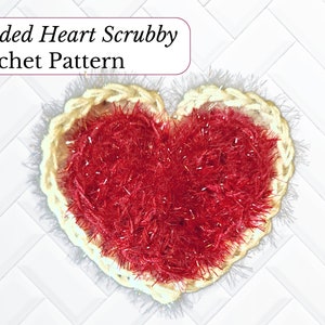 May include: A two-sided heart-shaped crochet scrubby with a red center and a cream-colored border. The scrubby is made with a fluffy yarn and is perfect for cleaning dishes or other surfaces.