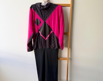 May include: A long-sleeved dress featuring a black and hot pink polka dot bodice with a high neckline and a solid black skirt. The bodice includes black geometric panels and a cinched waistline, creating a distinct contrast between the patterned top and the plain black bottom section.