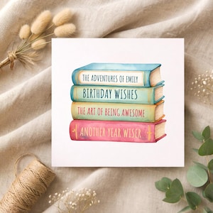 May include: A watercolour illustration of a stack of books. The titles read: "The Adventures of Emily," "Birthday Wishes," "The Art of Being Awesome," and "Another Year Wiser." The books are in blue, green, yellow, and pink.