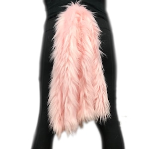 Puede incluir: Un accesorio de cola de disfraz de color rosa y esponjoso. La cola está hecha de piel suave y afelpada y está unida a una banda para la cintura.