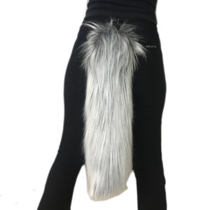 May include: A long, fluffy, gray and white faux fur tail with a black elastic strap for attaching to a belt or waistband.