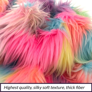 May include: Close-up of a rainbow colored faux fur fabric. The fabric has a soft, fluffy texture and is made of thick fibers.