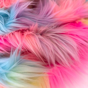 May include: Close-up of a rainbow colored faux fur fabric. The fur is soft and fluffy, with shades of pink, blue, and yellow.