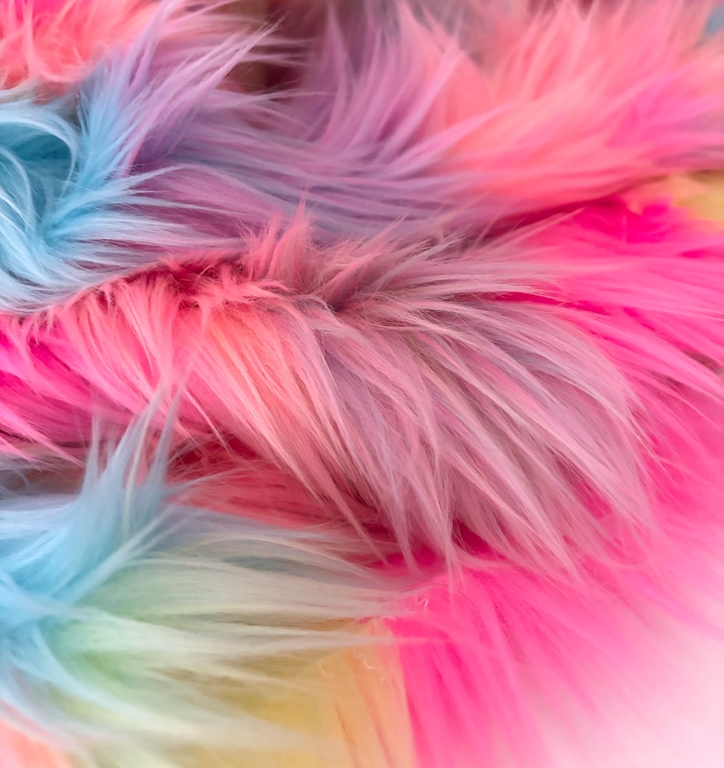 May include: Close-up of a rainbow colored faux fur fabric. The fur is soft and fluffy, with shades of pink, blue, and yellow.