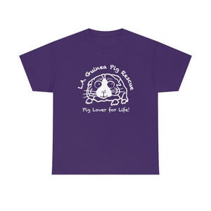 May include: A purple t-shirt featuring a white graphic of a guinea pig with the text "L.A. Guinea Pig Rescue" and "Pig Lover for Life!" in a circular design. The design is centered on the front of the shirt.