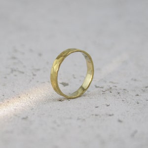 Könnte beinhalten: Ein einfacher Goldring mit gehämmerter Textur.