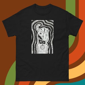 Peut inclure: T-shirt noir et blanc avec un motif graphique représentant une créature surréaliste à deux visages, l'un souriant et l'autre avec des dents acérées. La créature est entourée de lignes tourbillonnantes et de texte qui dit "WHY?" et "UNDER THE MIDDLE CRISIS".