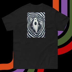 Peut inclure: T-shirt noir avec un motif de trois fantômes blancs dans un motif tourbillonnant noir et blanc.