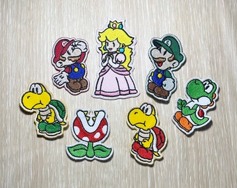 May include: Set of 9 embroidered iron-on patches featuring characters from the Super Mario Bros. video game series. The patches include Mario, Luigi, Peach, Toad, Yoshi, and a Piranha Plant.