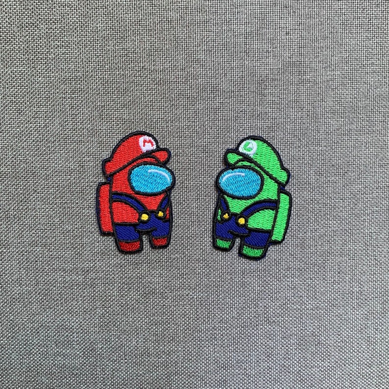 May include: Two embroidered patches featuring characters inspired by the video games Among Us and Super Mario. One patch is red with a Mario hat, the other is green with a Luigi hat. Both have blue visors, blue overalls, and are outlined in black.