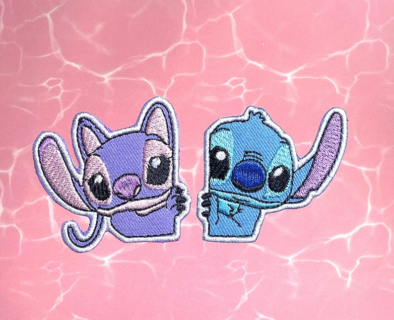 May include: Two embroidered iron-on patches featuring Stitch and Angel from the Disney movie Lilo & Stitch. Stitch is blue with a purple ear and Angel is purple with a pink ear.