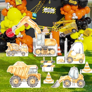 May include: Construction party decorations with yellow, orange, and black balloons.  The decorations include a yellow dump truck, a yellow excavator, a yellow cement mixer, a yellow forklift, and a yellow bulldozer.  The text on the signs reads "Under Construction", "Caution Party Zone", "Danger", "Stop", "Detour", and "Dump Gifts Here".