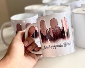 May include: White ceramic mug with a brown illustration of three women wearing headscarves. The mug has the names "Sharmila, Aminah, Halima" written on the bottom.