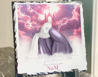 May include: A slate plaque with a pink and purple sky background and two figures in white and purple robes. The text on the plaque reads "You will be with those whom you love. -SAHIH AL-BUKHARI 3688- N&M"