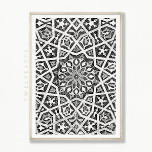 Könnte beinhalten: Schwarz-weißes geometrisches Muster mit einem Sternenausbruch-Design. Das Muster ist in einem hellen Holzrahmen gerahmt.