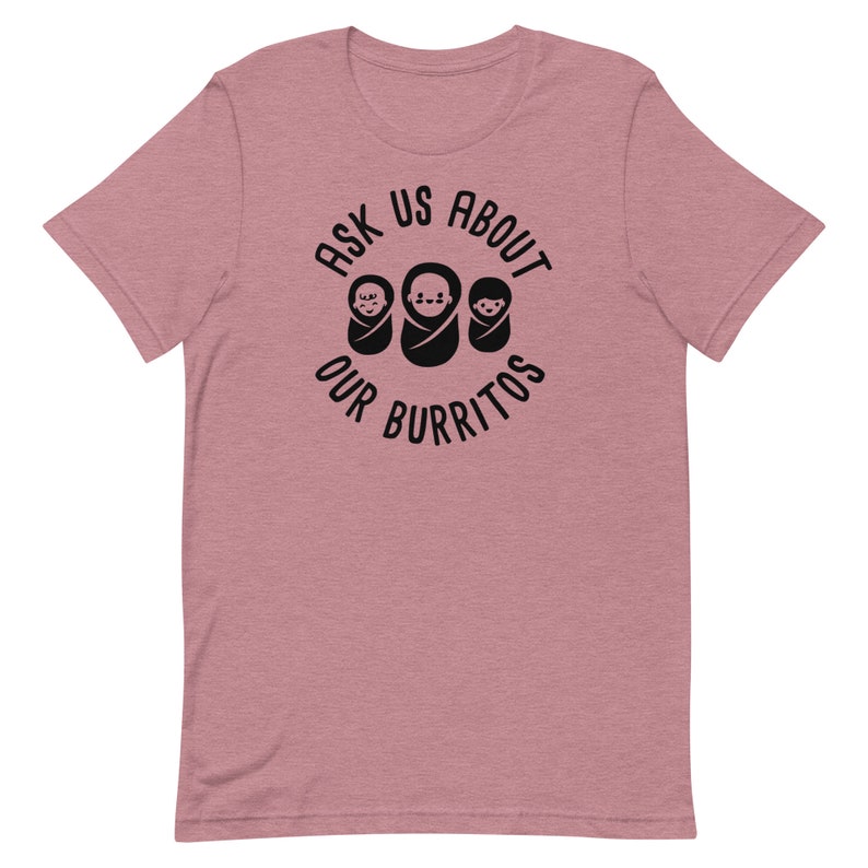 Puede incluir: Una camiseta de color rosa claro jaspeada con un gr&aacute;fico negro que dice "Ask Us About Our Burritos" con tres iconos de beb&eacute;s burritos.