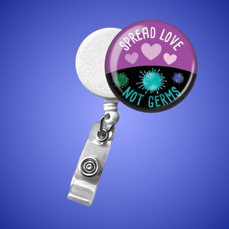 May include: A retractable badge reel with a round, purple and black design. The design features the text "SPREAD LOVE NOT GERMS" with heart and germ illustrations. The reel has a white disc, a metal clip, and a clear plastic strap.