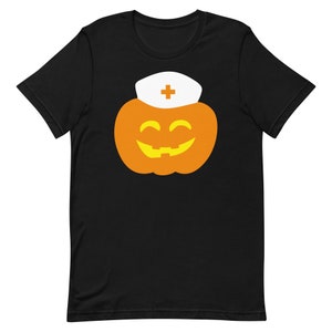K&ouml;nnte beinhalten: Schwarzes T-Shirt mit einem Motiv eines l&auml;chelnden orangefarbenen K&uuml;rbisses, der einen wei&szlig;en Krankenschwesterhut mit einem roten Kreuz tr&auml;gt.