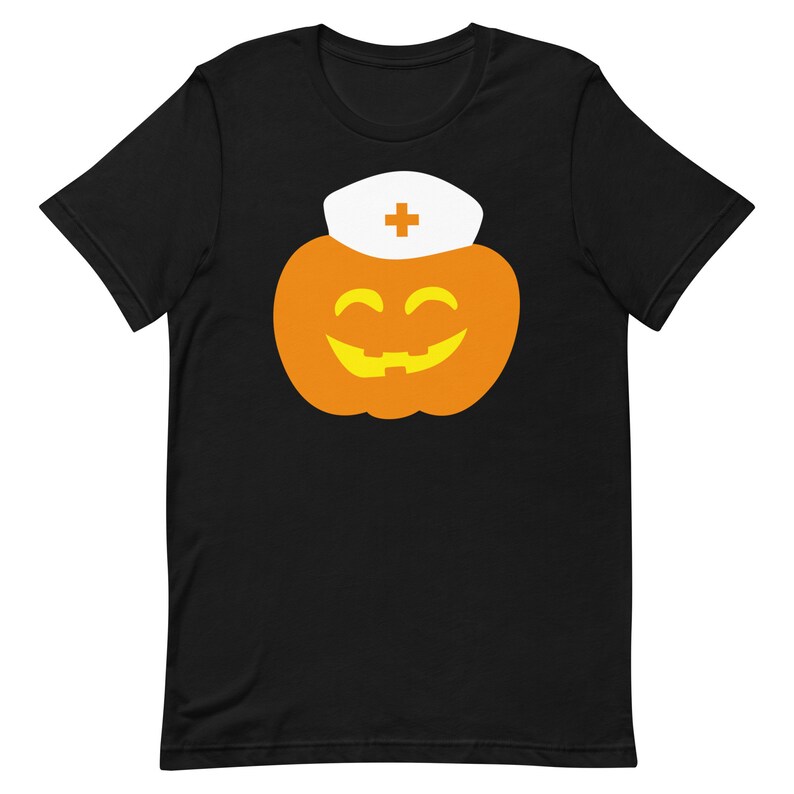 K&ouml;nnte beinhalten: Schwarzes T-Shirt mit einem Motiv eines l&auml;chelnden orangefarbenen K&uuml;rbisses, der einen wei&szlig;en Krankenschwesterhut mit einem roten Kreuz tr&auml;gt.