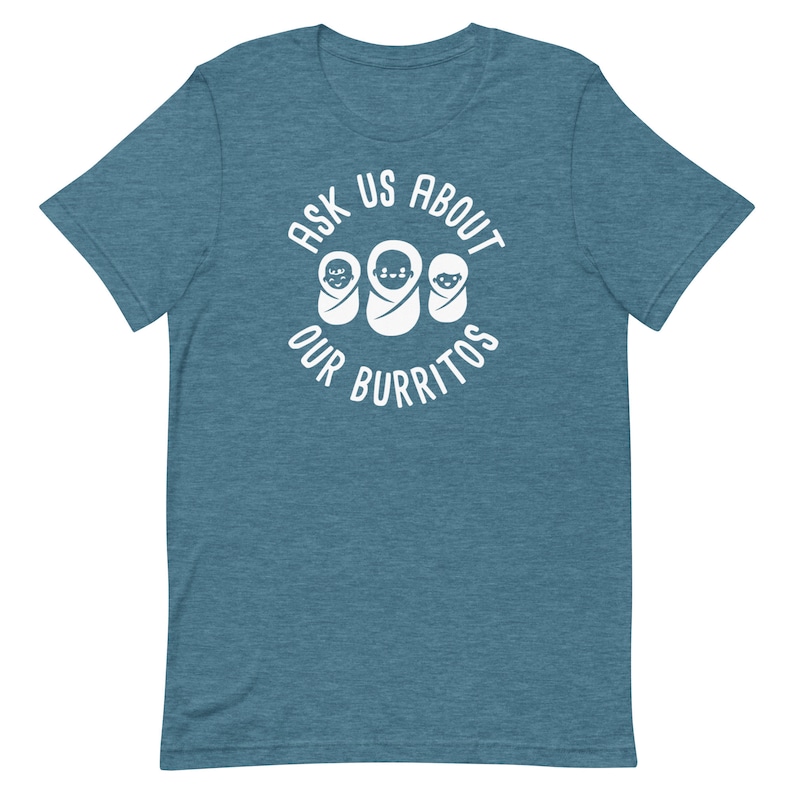Puede incluir: Una camiseta azul turquesa con un gr&aacute;fico circular blanco que dice "Ask Us About Our Burritos" con tres caras de beb&eacute;s dentro del c&iacute;rculo.